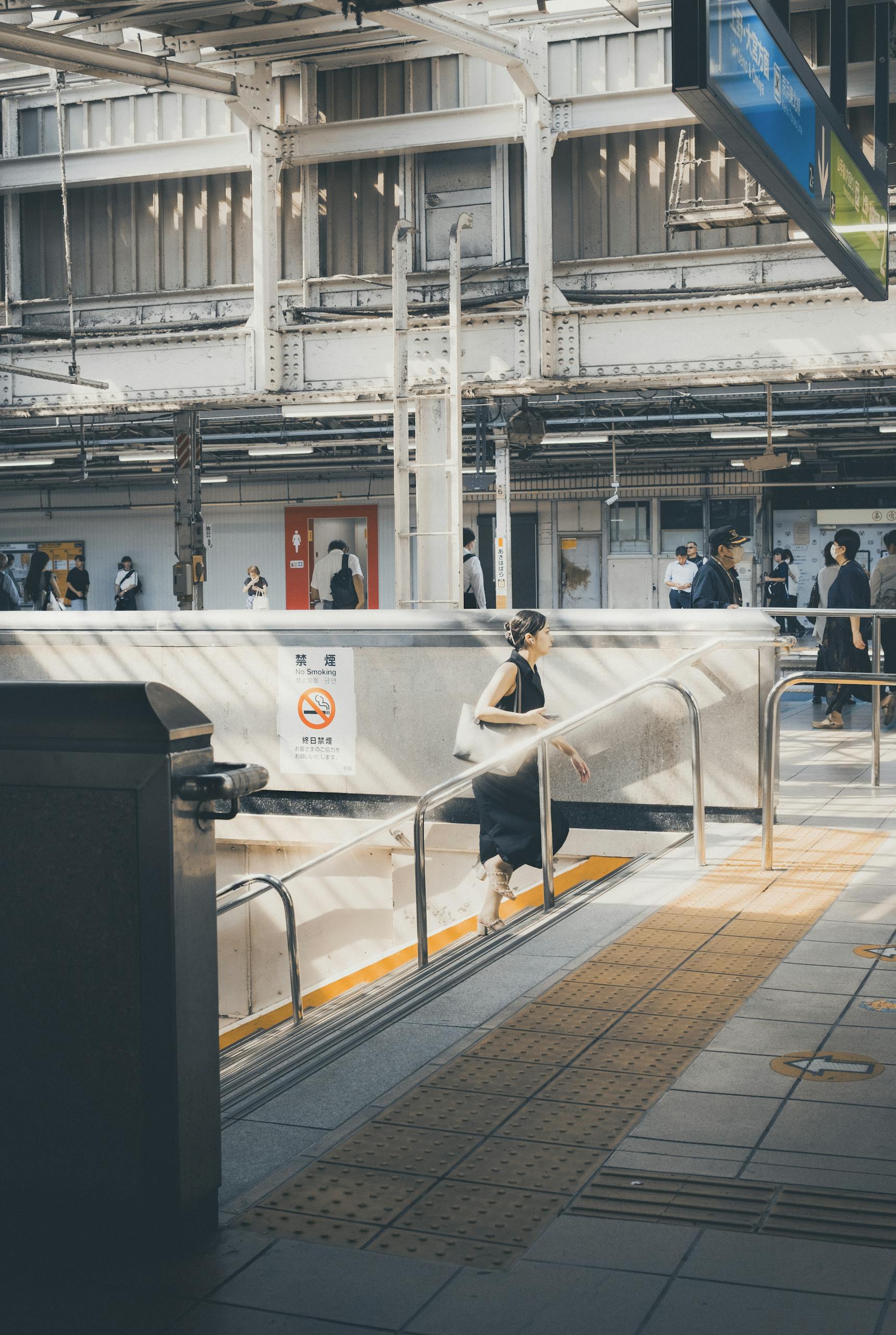 Commuters at a train station platform in Tokyo, Japan during the day.